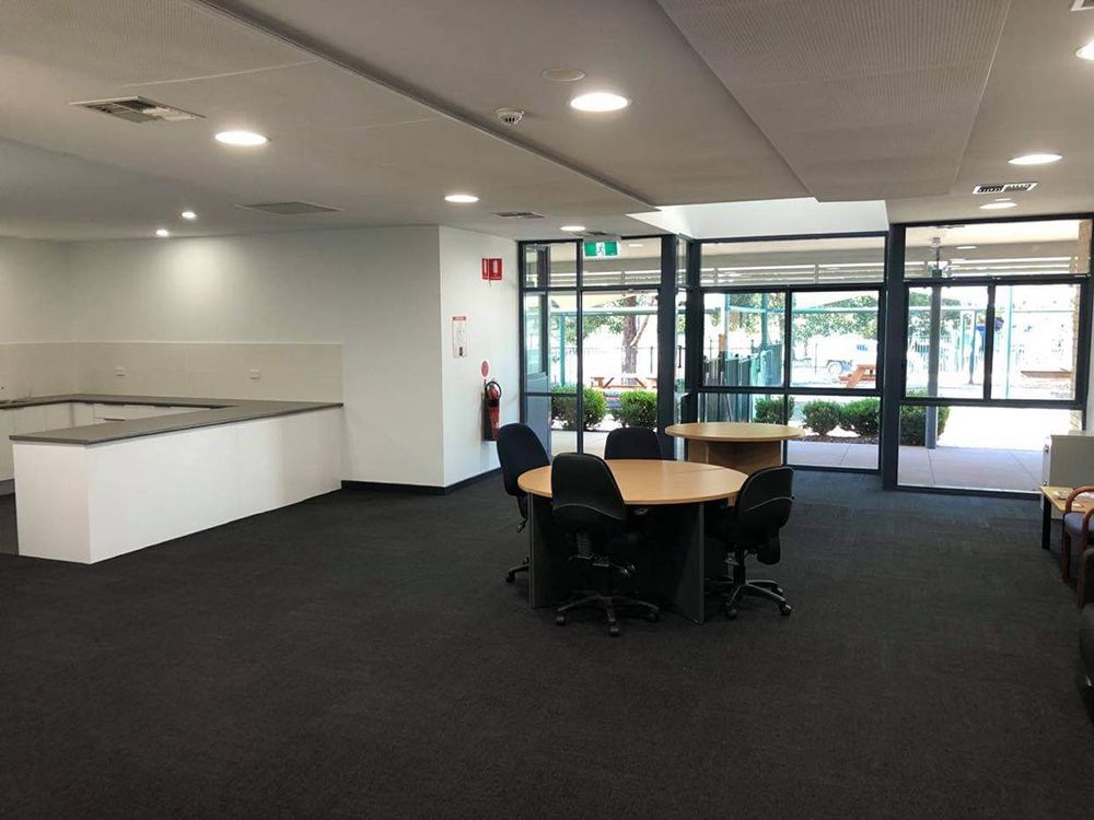 A Large Room With A Circle Table And Chairs With Lights — Entire Trades in Singleton, NSW