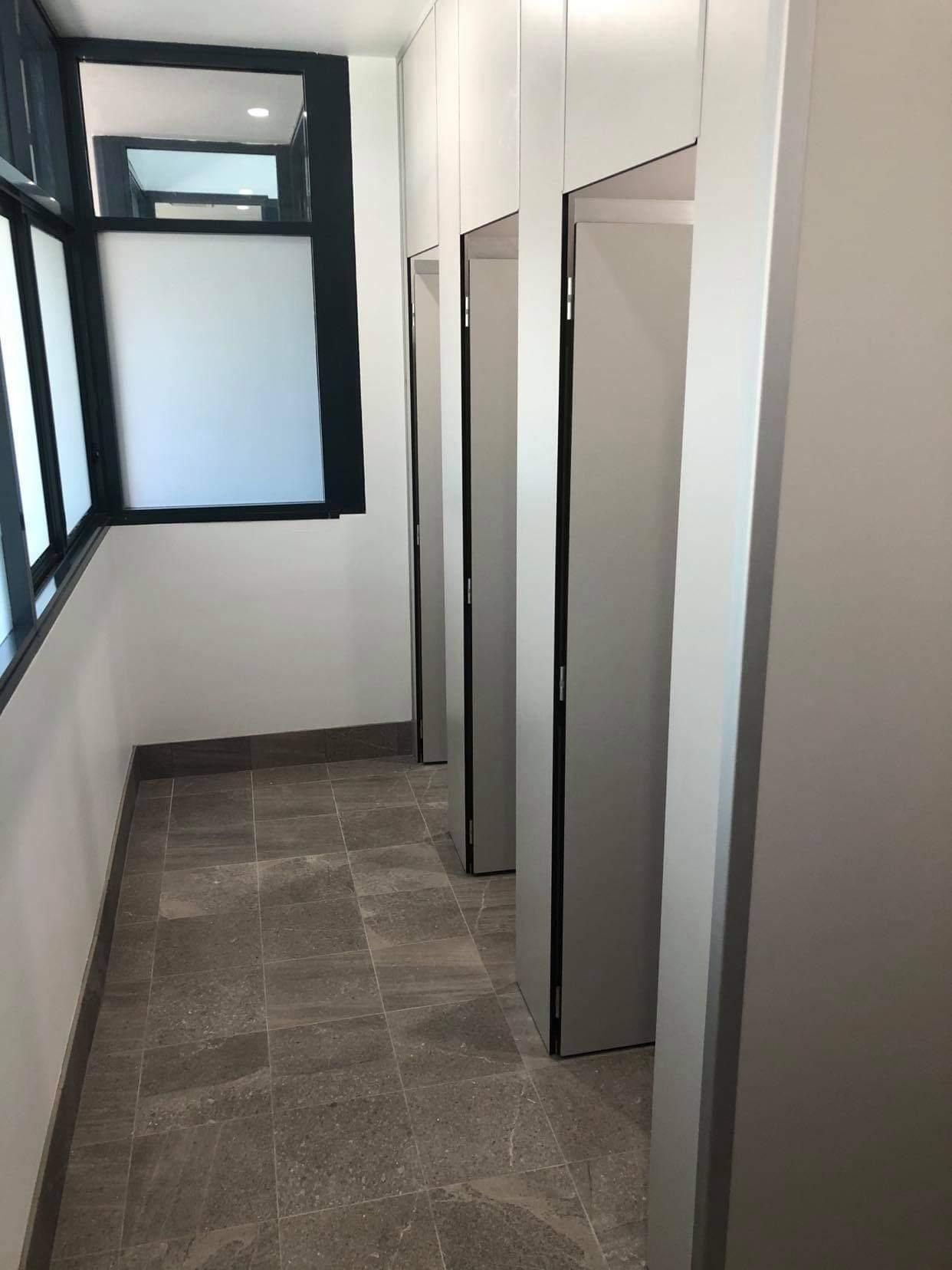 A Long Hallway with A Lot of Doors and A Window — Entire Trades in Maitland, NSW