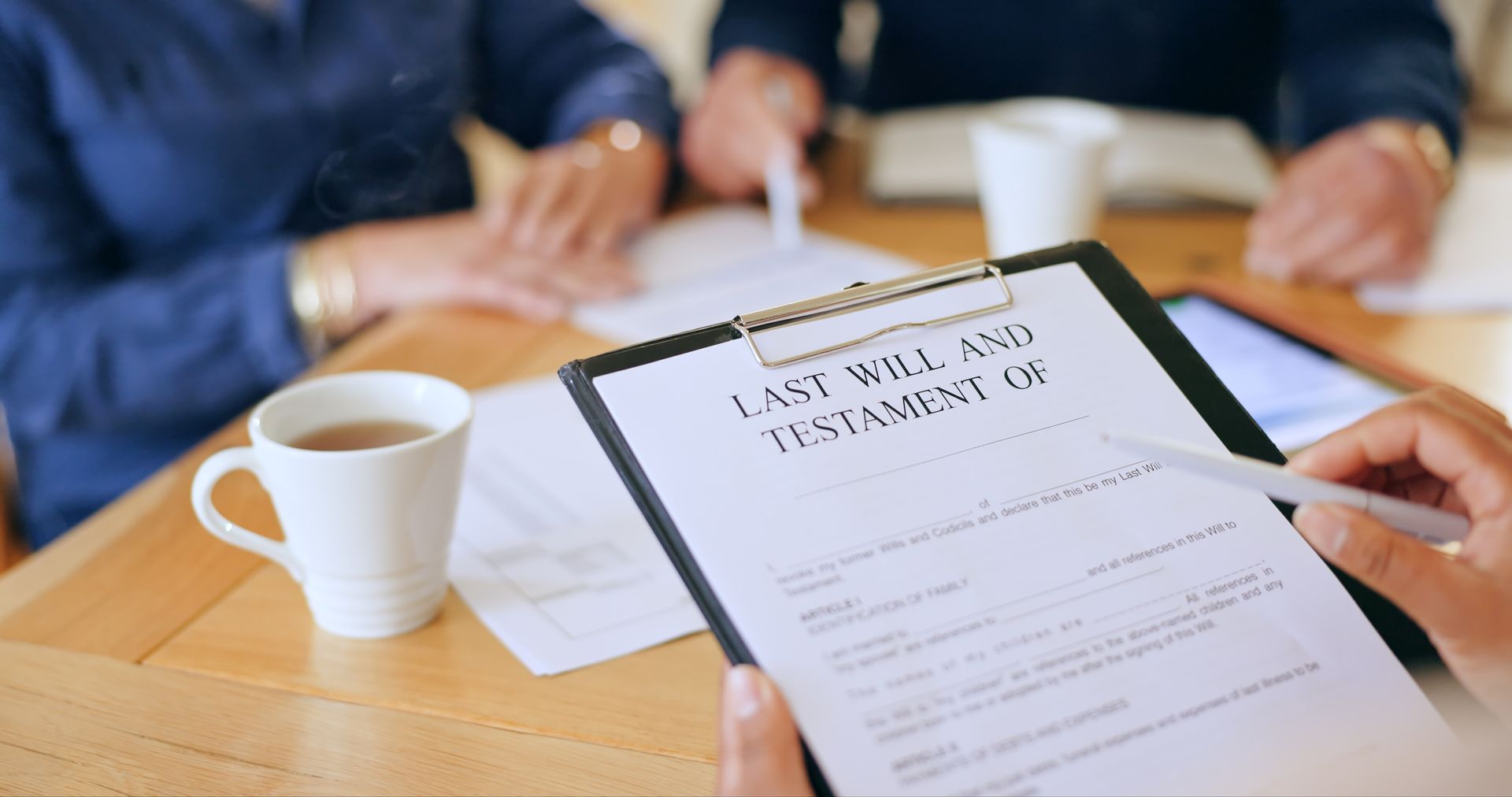 A wills lawyer reviewing estate planning documents with a couple at his office.
