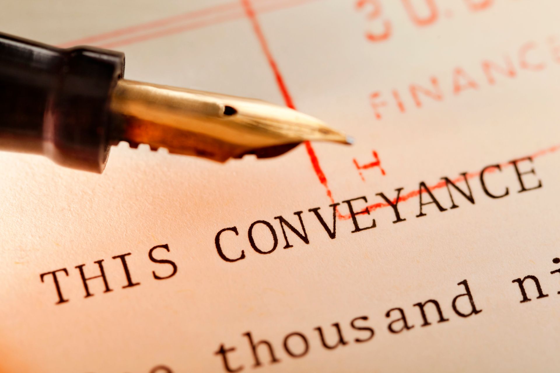 Fountain pen rests on a document with partial legal text visible.