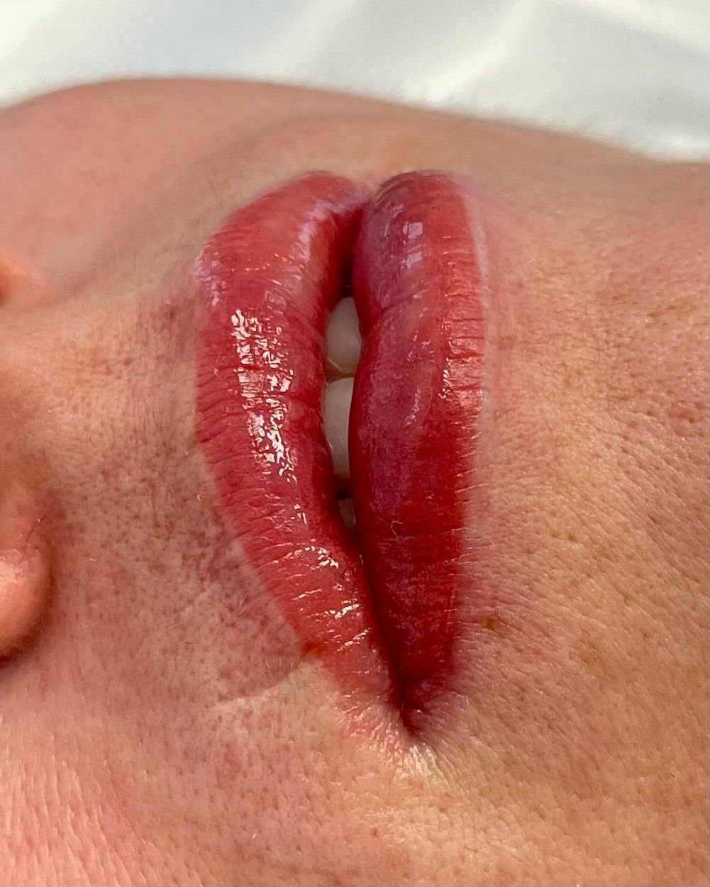 A close up of a woman 's lips with red lipstick.