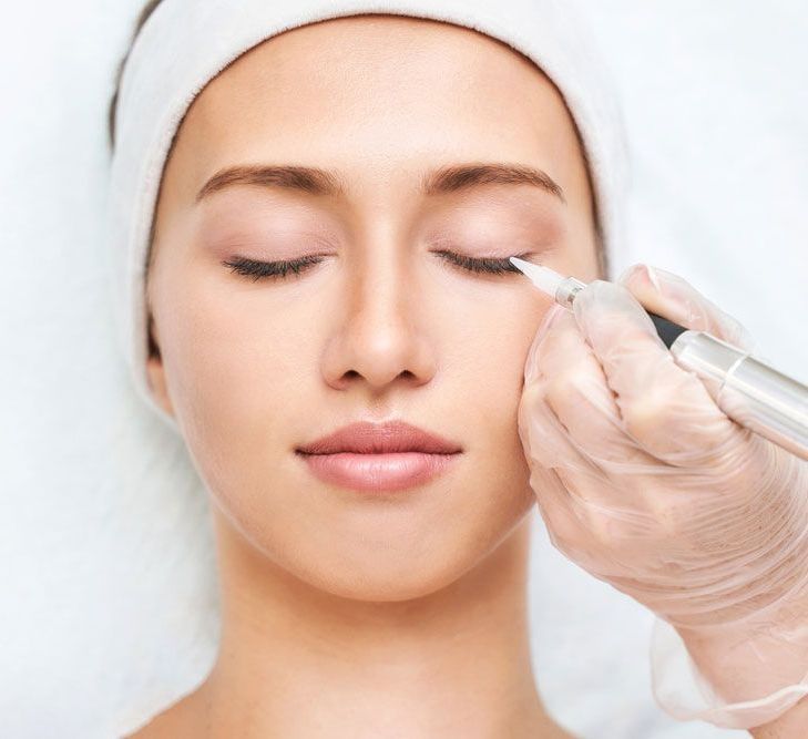 A woman is getting a tattoo on her eye