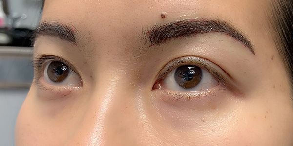 A close up of a woman 's eyes with a spot on her forehead.