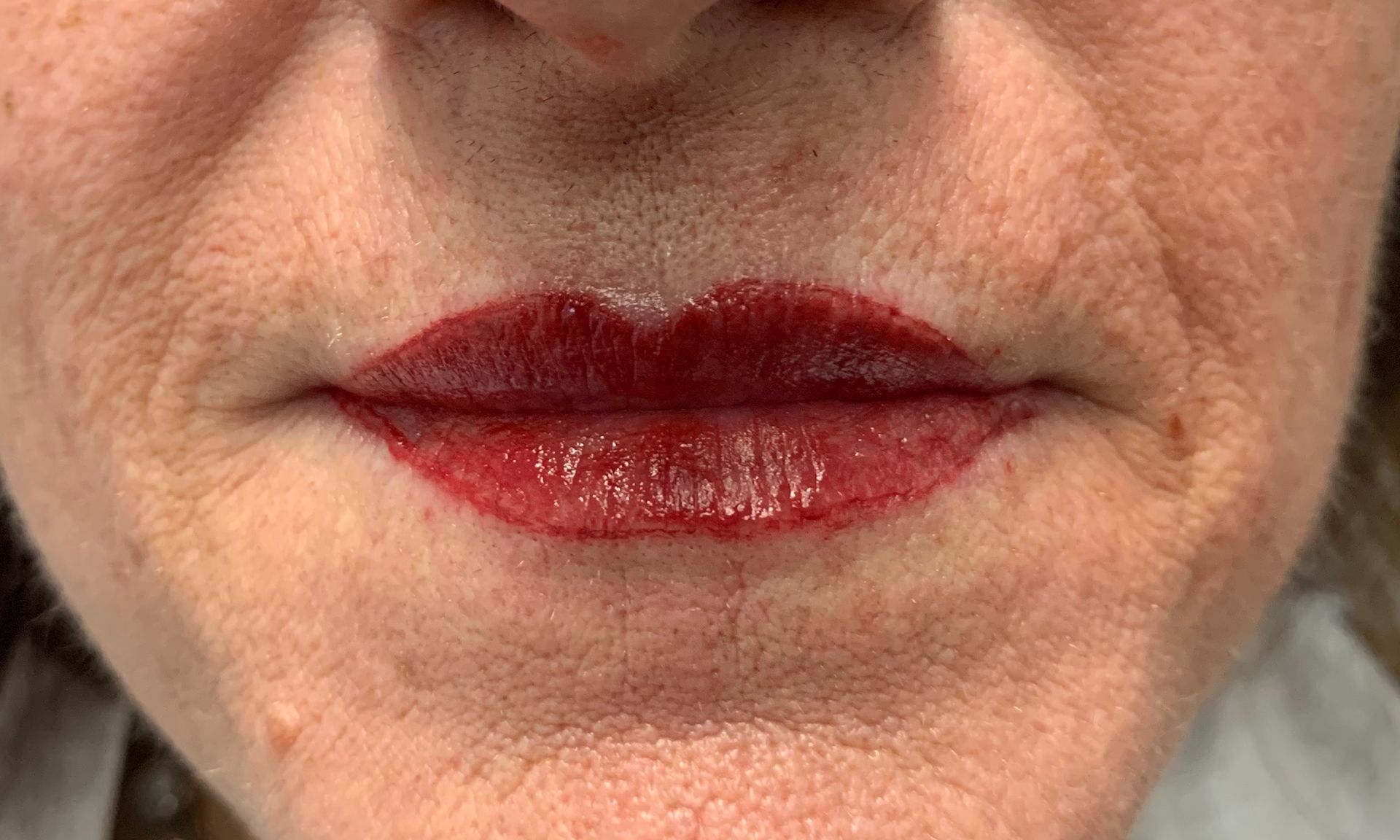 A close up of a woman 's lips with red lipstick.