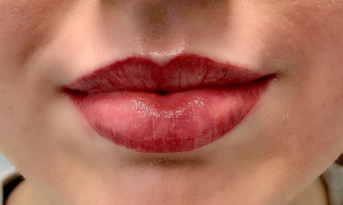 A close up of a woman 's lips with red lipstick.