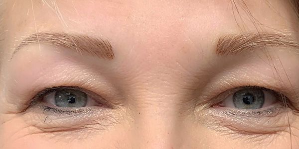 A close up of a woman 's eyes without makeup.