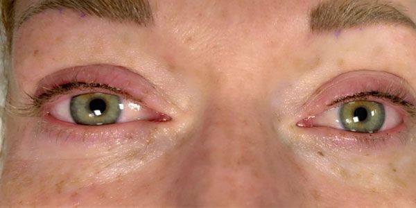 A close up of a woman 's eyes with green eyes.