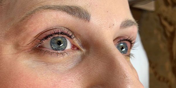 A close up of a woman 's blue eyes looking up.