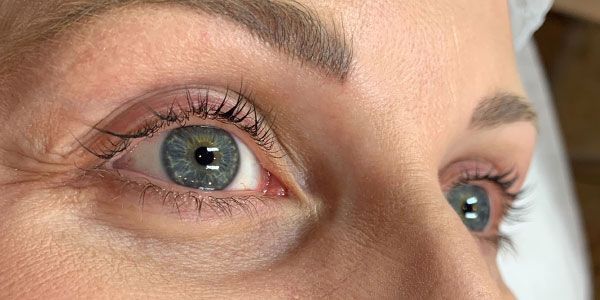 A close up of a woman 's blue eyes looking up.
