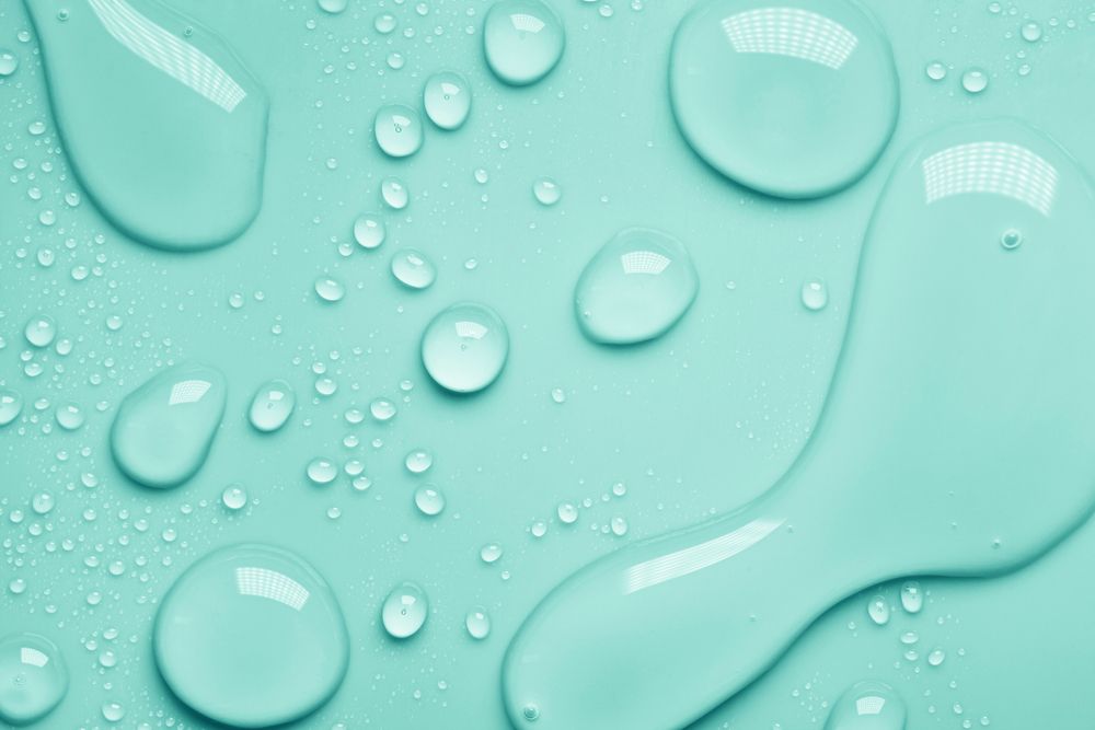 A close up of water drops on a blue surface.