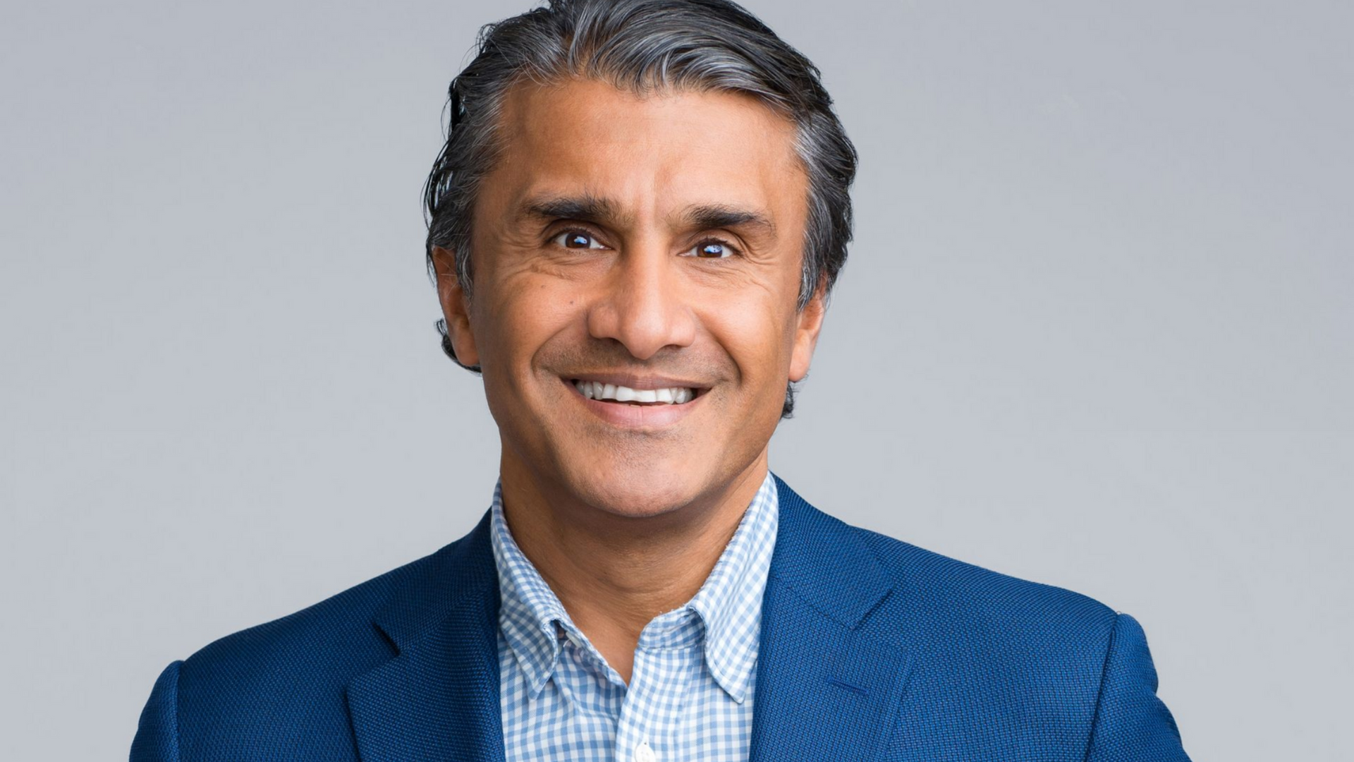 Ron Shaich is smiling in front of a panera bread store