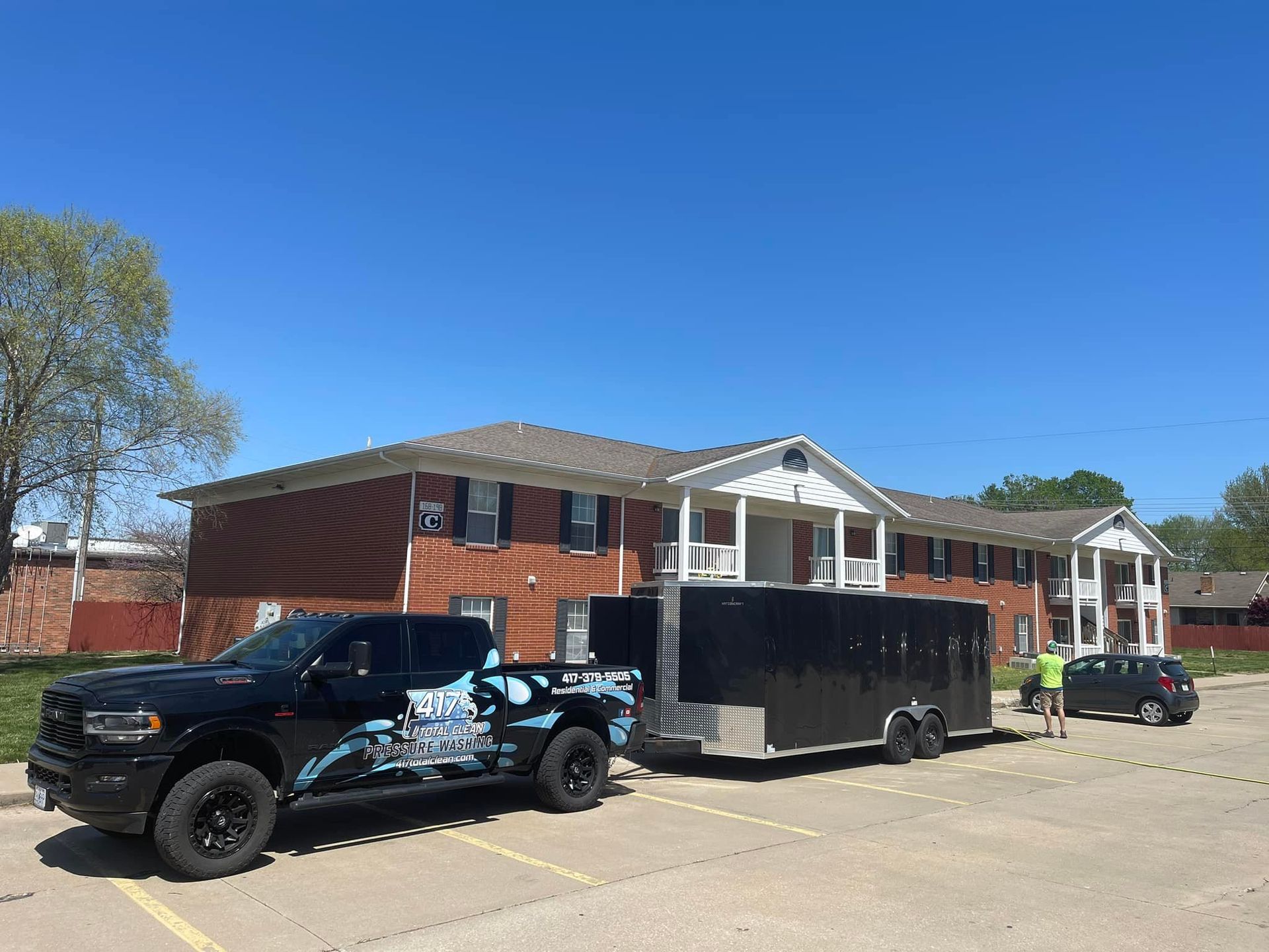 A truck and trailer are parked in front of a building