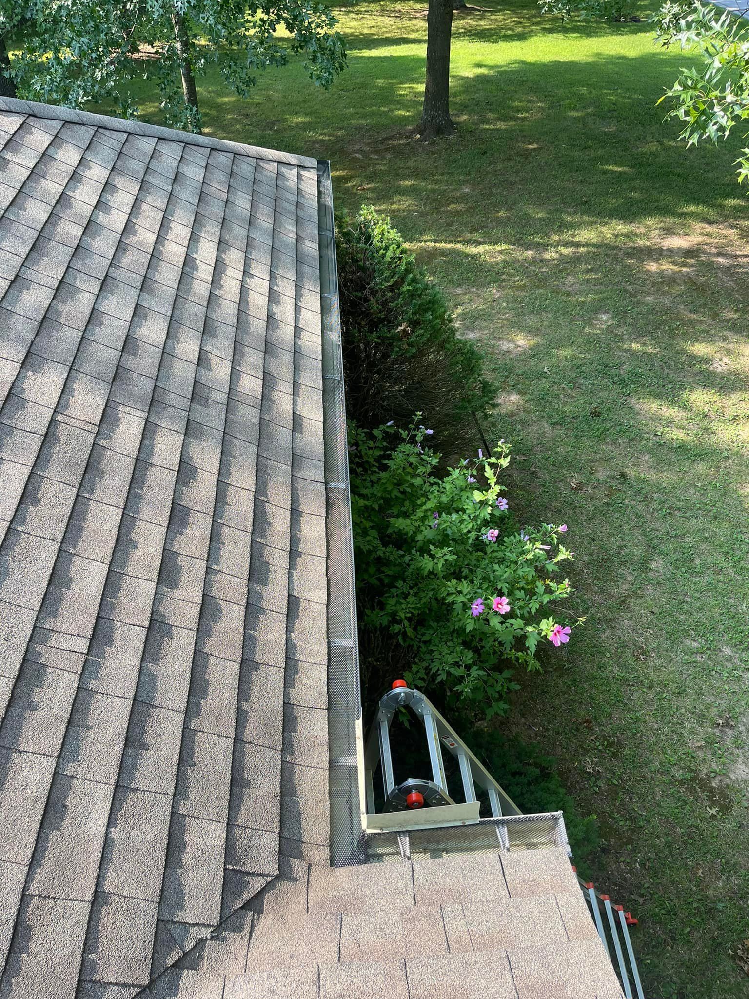 An aerial view of a roof with a gutter in the backyard.