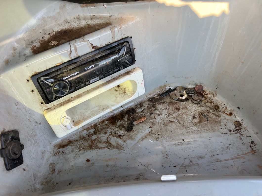 A dirty bathtub with a radio in it.