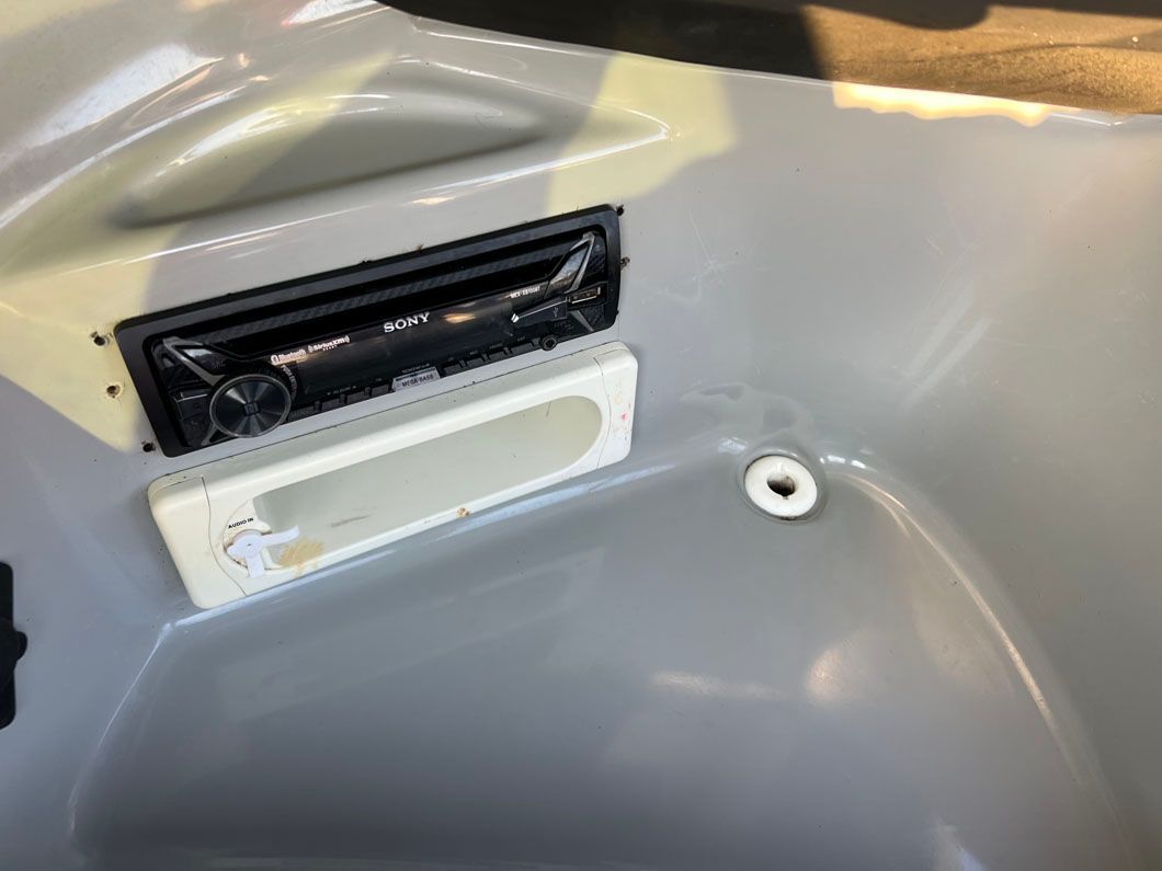 A close up of a radio in a bathtub.