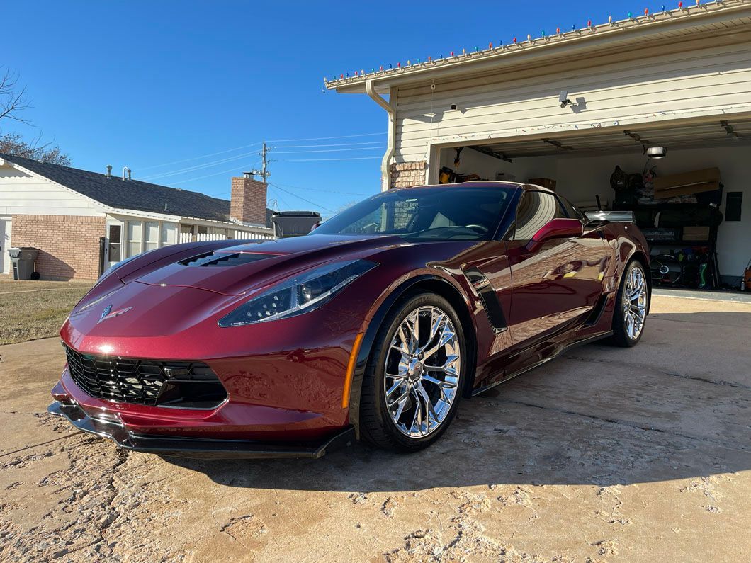 A red sports car is parked in front of a garage.
