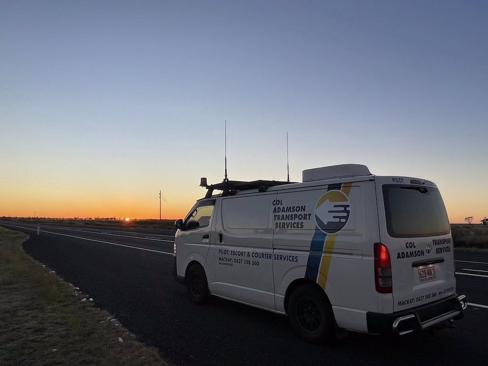 White Van With Company Logo on Road at Sunrise — Col Adamson Transport Services in Rockhampton, QLD