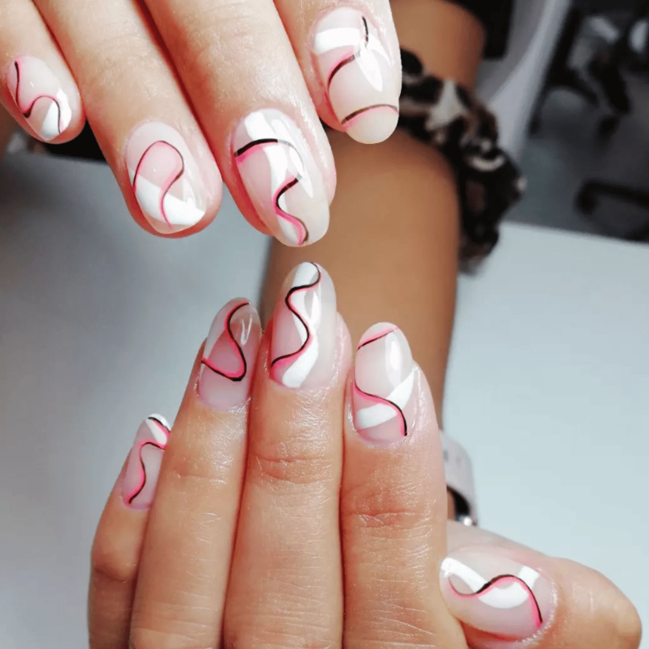 Un primer plano de las uñas de una mujer con remolinos.