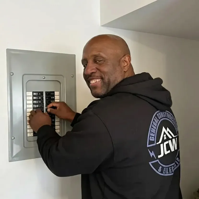 Man smiling while entering a code on a wall-mounted security keypad.