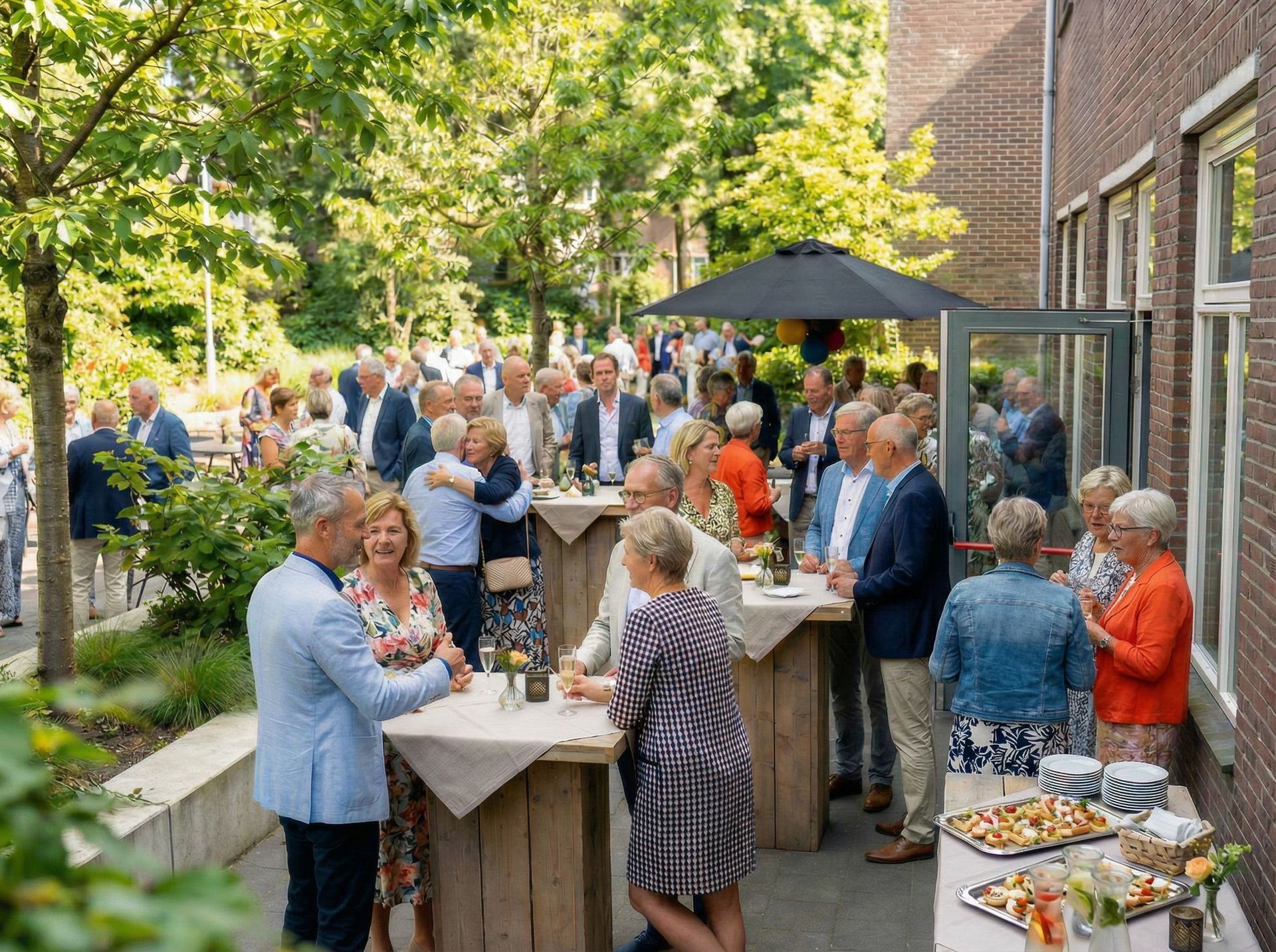 Gasten mengen zich onder elkaar op een tuinfeest in de buitenlucht met drankjes en buffetten naast een bakstenen gebouw.