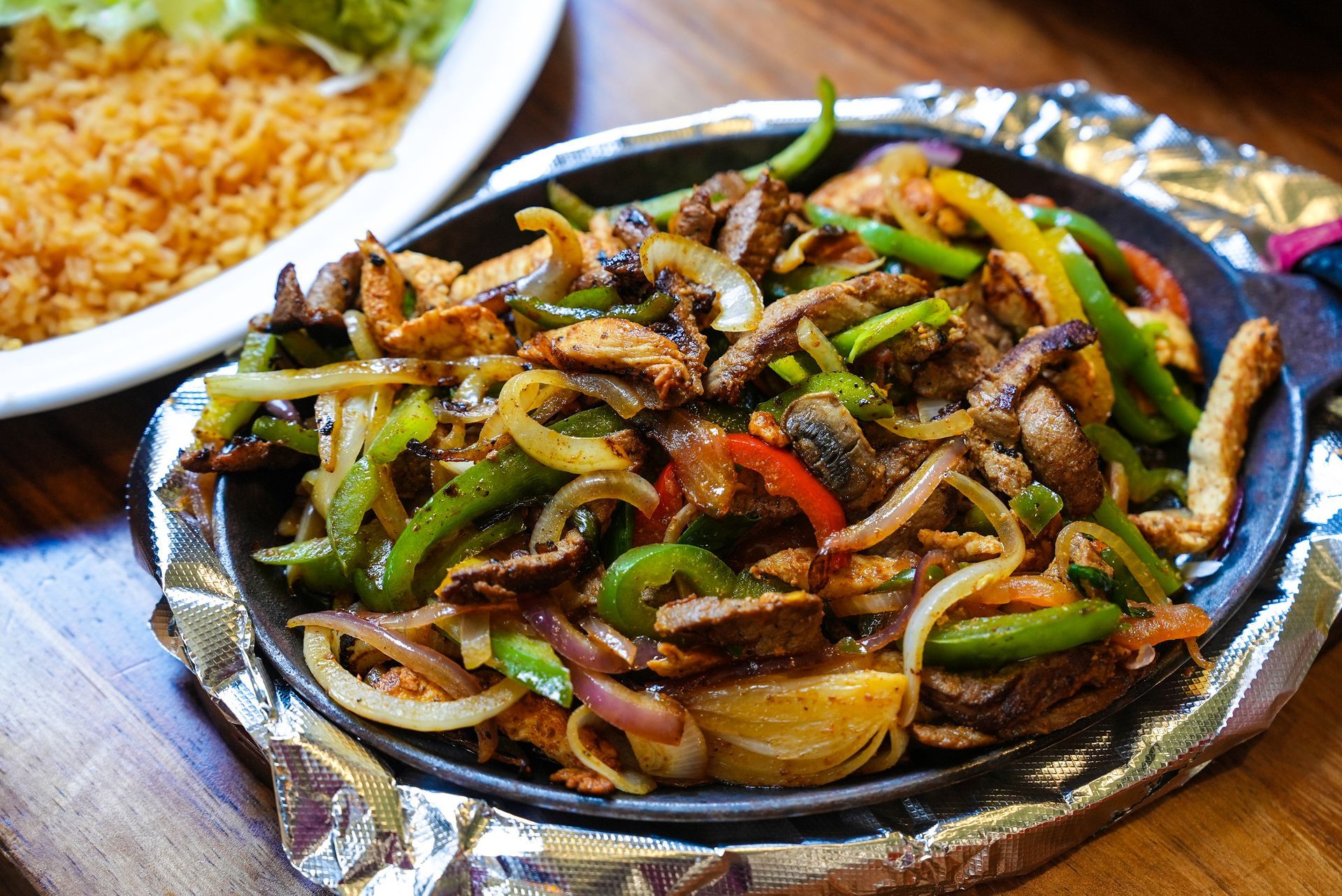 A plate of food with a plate of rice in the background
