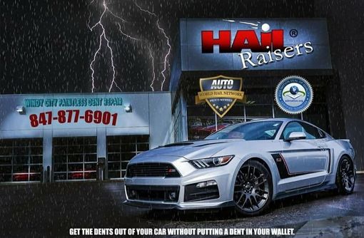 Silver sports car in front of Hail Raisers auto shop with lightning backdrop and phone number sign