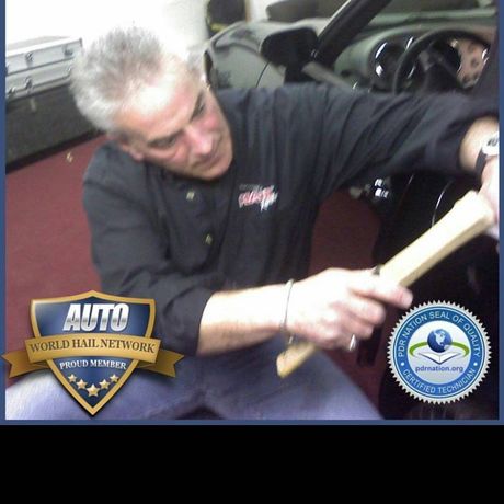 Man working inside a car, leaning over the interior with tools; Auto World Half Network and circular logo overlays.