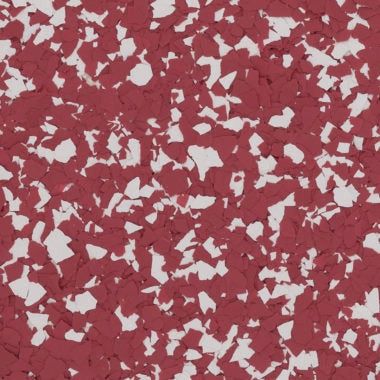 A close-up of a decorative epoxy floor finish with a pattern of dark red and white irregular flakes.