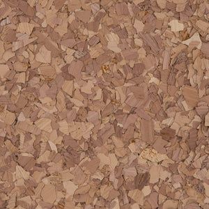 Close-up view of a natural cork texture with varied light and dark brown wood-like shavings and particles.