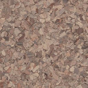 A close-up, top-down view of textured cork flooring with variegated shades of light and medium brown wood particles.