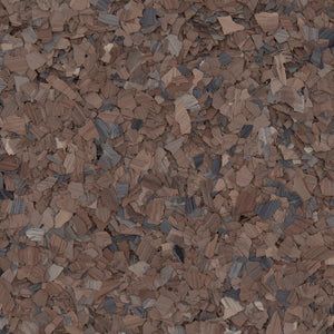 A close-up of brown, charcoal, and tan decorative paint chips used for epoxy flooring or textured surfacing.