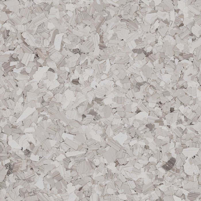 A close-up texture of beige and grey vinyl flooring chips in an irregular, speckled pattern.