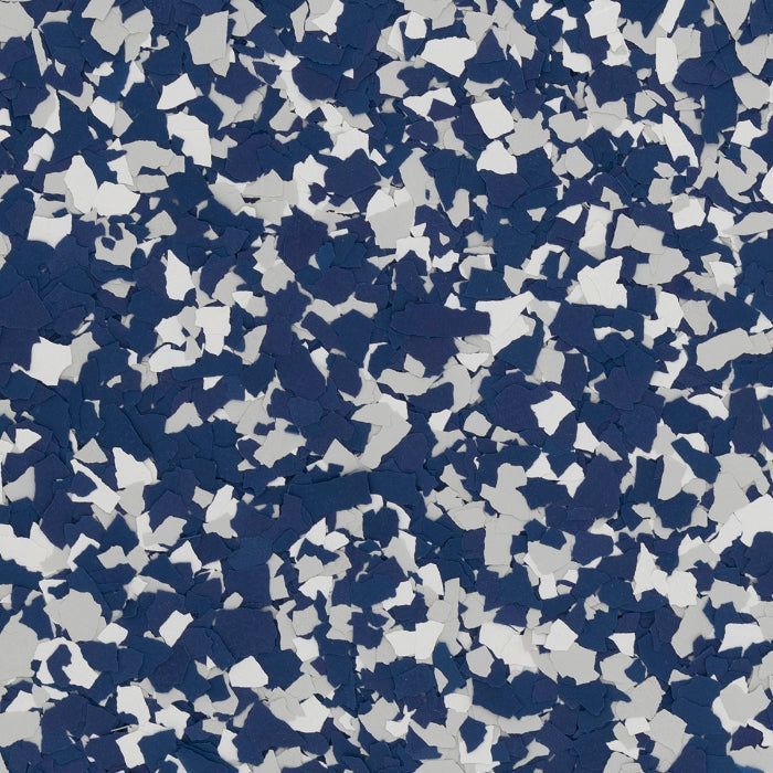 A close-up of dark blue, light gray, and white decorative floor flakes scattered in a dense, mottled pattern.