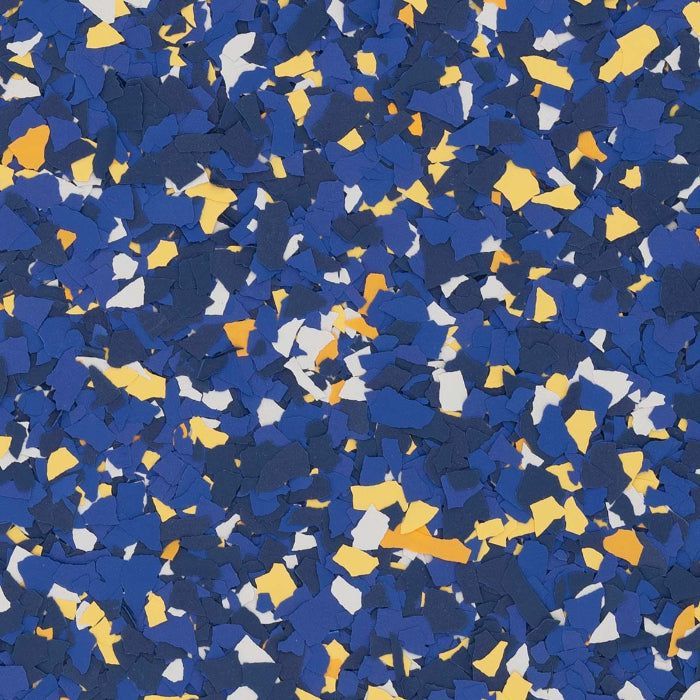 A close-up of decorative floor chips in shades of royal blue, navy, white, and yellow scattered on a surface.