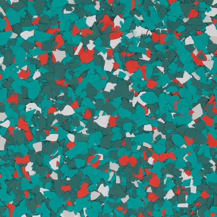A close-up of decorative vinyl flooring chips in shades of teal, bright red, and white.