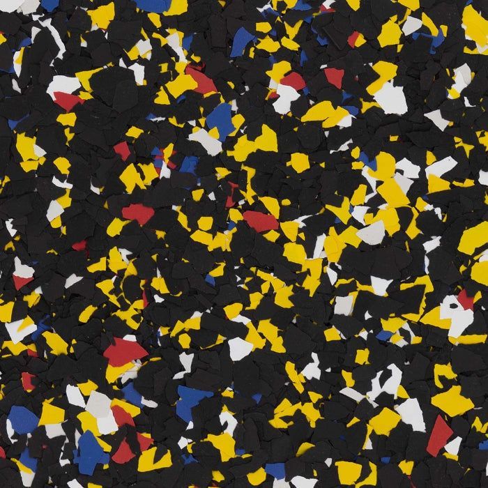 A close-up texture of black rubber flooring flecked with small, irregular chips of yellow, white, red, and blue.