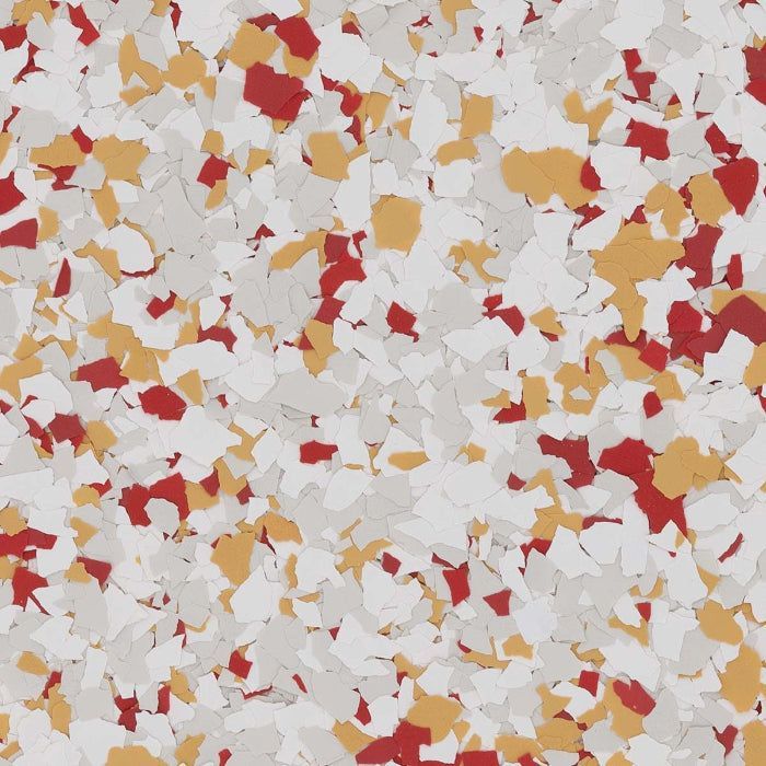 A close-up of a decorative flooring texture with scattered red, gold, and white vinyl chips against a light gray background.