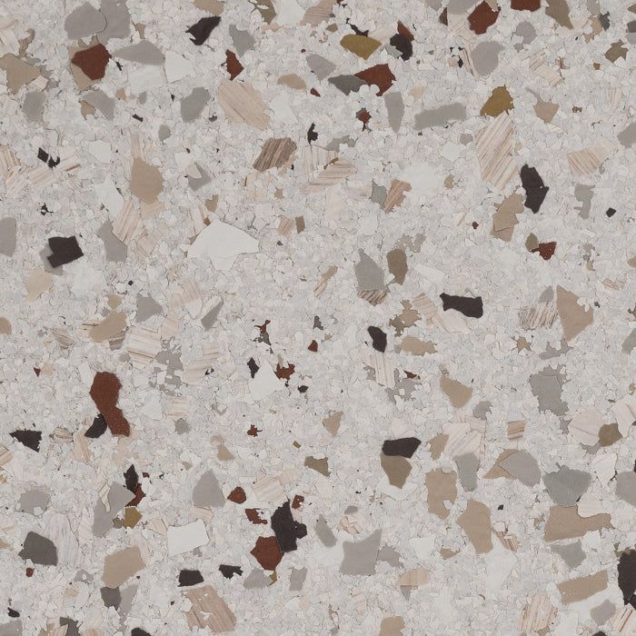 Terrazzo-style surface with irregular flecks of brown, gray, black, and tan on a light, speckled off-white background.