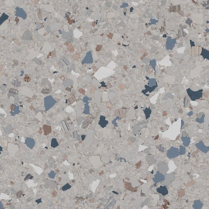 Terrazzo-style surface with a light gray speckled background and irregular chips in blue, white, brown, and charcoal gray.
