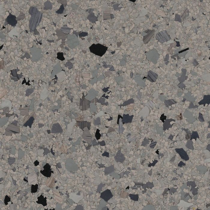 A gray, beige, and black speckled epoxy flake flooring pattern with a textured, multi-colored confetti appearance.