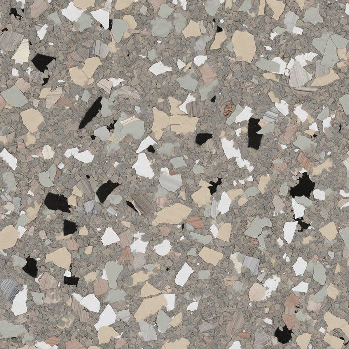A close-up of grey epoxy flooring scattered with white, tan, and black decorative flakes.
