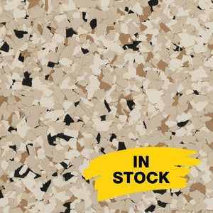 A close-up of tan, beige, and black paint chips for flooring, featuring a yellow 