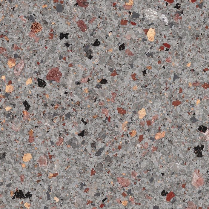 A grey, textured surface with scattered, small chips in red, black, and tan, resembling terrazzo or granite flooring.