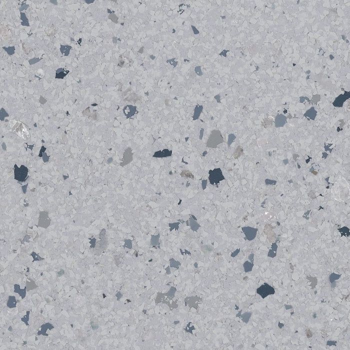 Light gray textured surface with speckled fragments in shades of dark blue, charcoal, and light gray.
