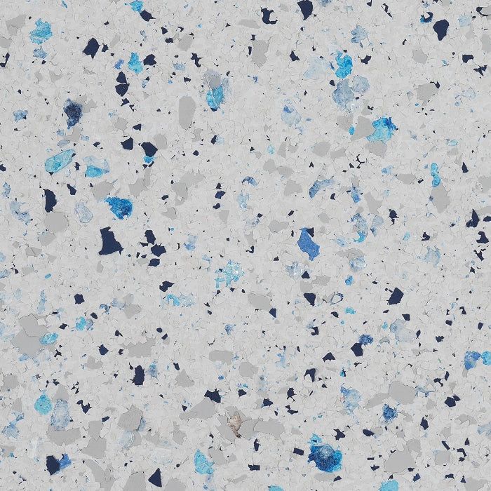 Close-up of a light gray floor coating texture speckled with small, irregular flakes in shades of blue, navy, and gray.