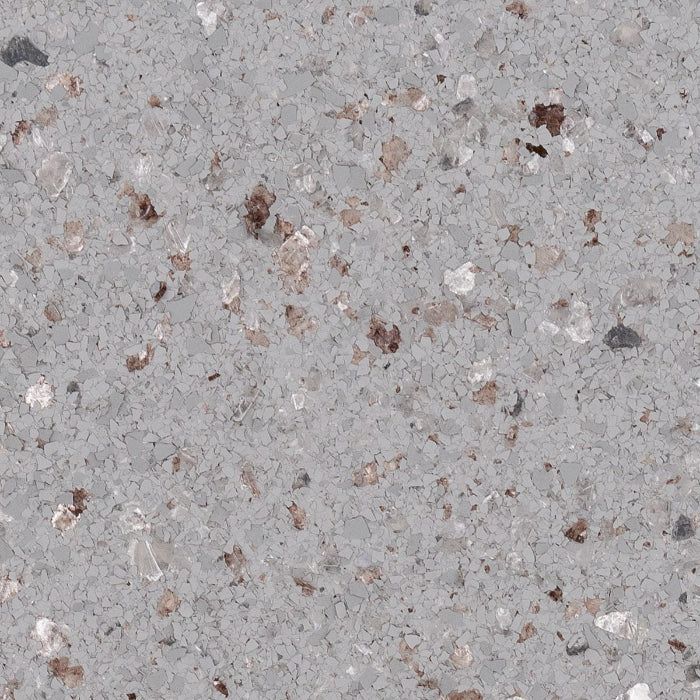 Close-up of a light gray quartz countertop with embedded flecks of brown, white, and dark gray stone.