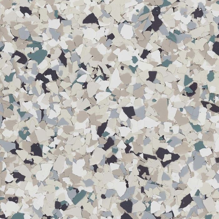 A close-up of decorative vinyl chips for flooring in a mix of white, beige, light gray, dark gray, and teal.