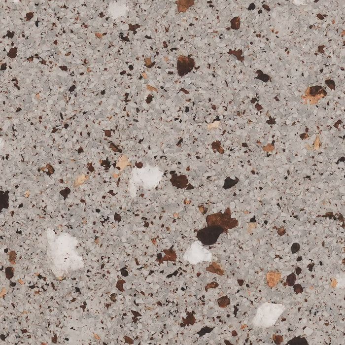 A close-up of a speckled granite or composite countertop surface with light gray, dark brown, and white flecks.
