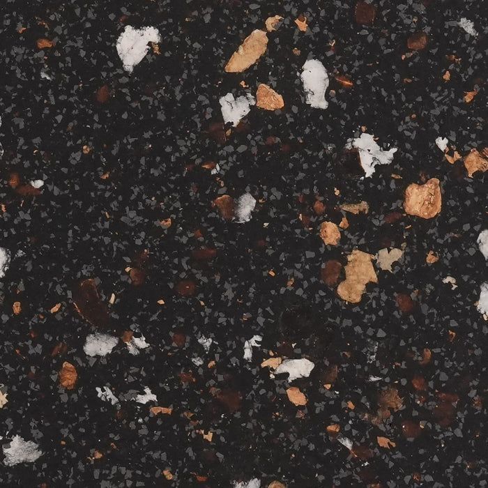 Black composite surface with scattered white and tan flecks of varying sizes.