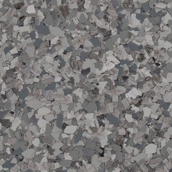 A close-up view of grey, white, and charcoal speckled vinyl flooring chips or flakes in a scattered, textured pattern.